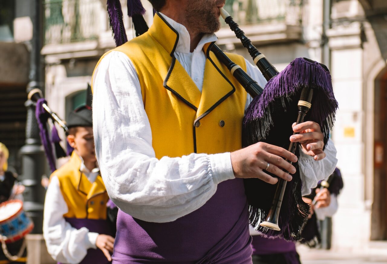 a man in a yellow vest playing a bagpipe